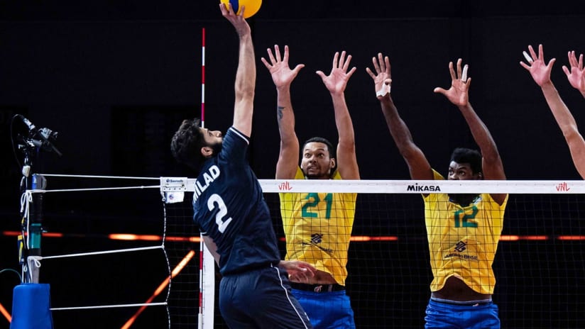 Milad Ebadipour spikes against the block of Alan Souza and Isac Santos during a VNL 2021 game