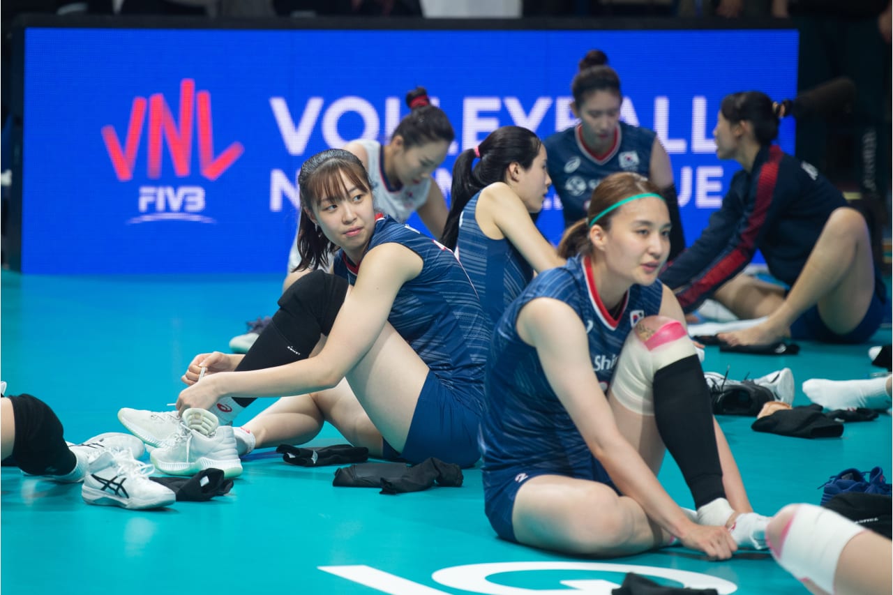 Korean players stretching after their match against Serbia at the 2019 FIVB Volleyball Nations League.