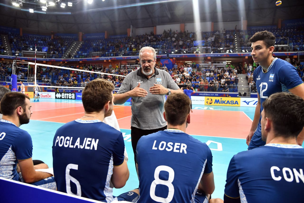 Coach Marcelo Mendez lines his players on the bench to give instructions at the 2019 FIVB Volleyball Nations League.