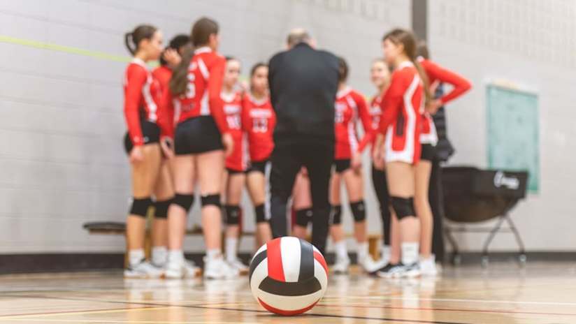 A volleyball coach discussing volleyball formations with his team