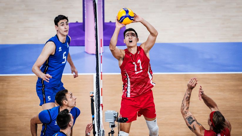 American setter Micah Christenson works against the Italian block at the net