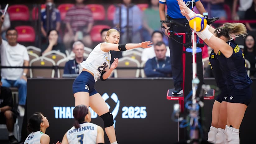 Japan’s Yoshino Sato tries to spike past Diana Meliushkyna’s block